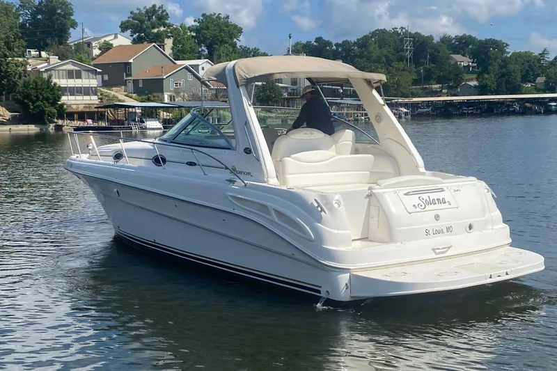 Slide: The Image of 2001 Sea Ray 340 Sundancer boat on calm water near residential area. - 2