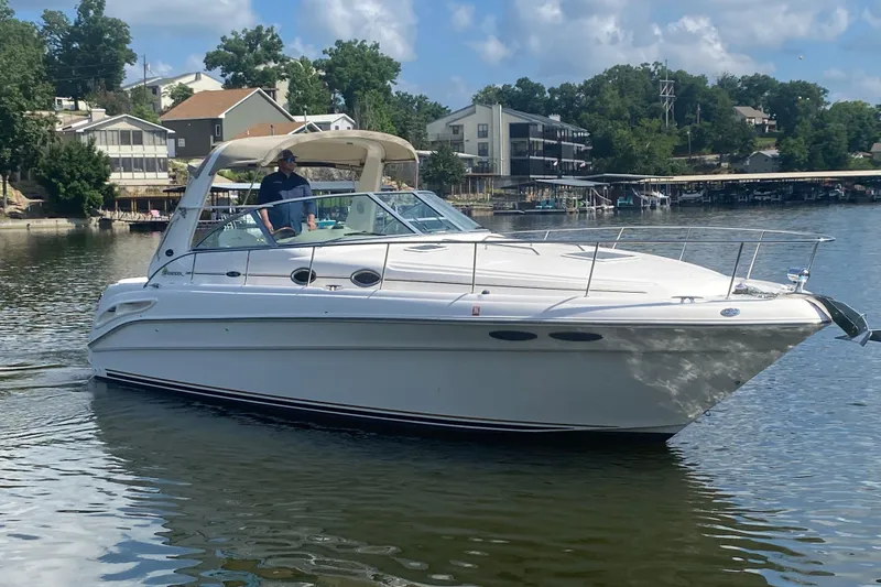 Slide: The Image of 2001 Sea Ray 340 Sundancer cruising on a calm lake near residential area. - 6