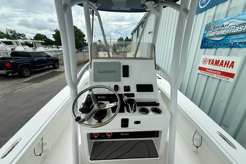 Slide: The Image of 2025 BlackJack 256 Coastal boat console with Garmin navigation, steering wheel, and controls. - 24