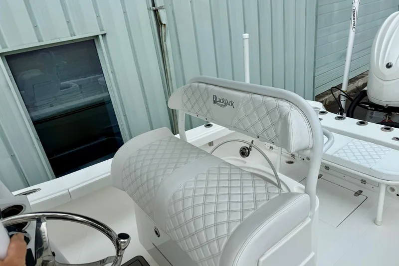 Slide: The Image of 2025 BlackJack 256 Coastal boat interior with quilted seating and steering wheel. - 6