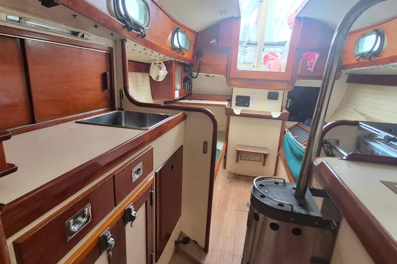 Slide: The Image of Interior of 1996 Morris Yachts Frances, featuring wooden cabinetry and compact kitchen area. - 13
