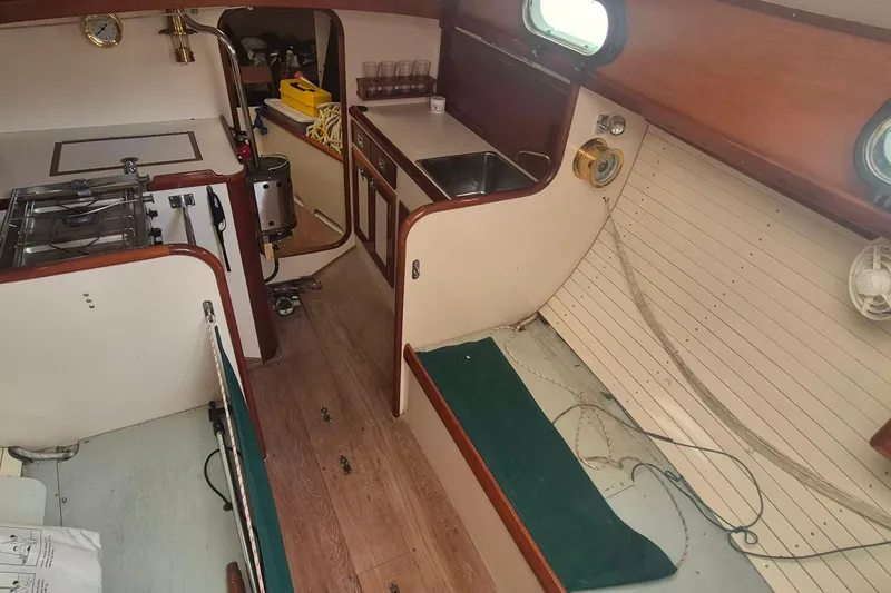 Slide: The Image of Interior of a 1996 Morris Yachts Frances sailboat, featuring a compact kitchen and seating area. - 22