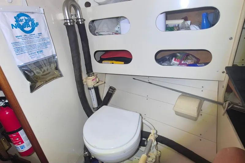 Slide: The Image of Compact yacht bathroom with toilet, storage shelves, and moisture absorber on a 1996 Morris Yachts Frances. - 24