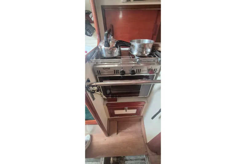 Slide: The Image of Compact kitchen area in a 1996 Morris Yachts Frances, featuring a stove and cookware. - 34