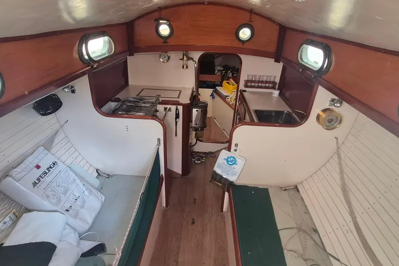 Slide: The Image of Interior of a 1996 Morris Yachts Frances sailboat, featuring a compact kitchen and seating area. - 8
