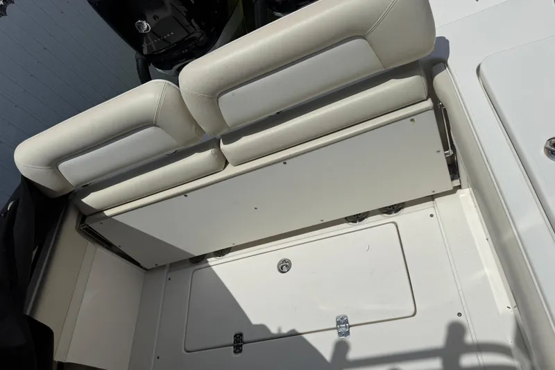 Slide: The Image of 2015 Blackwood 27 boat interior with white cushioned seating and storage compartment. - 19