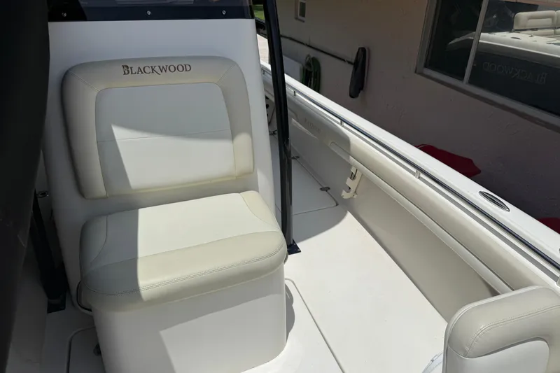 Slide: The Image of Interior of a 2015 Blackwood 27 boat featuring white seating and sleek design. - 22