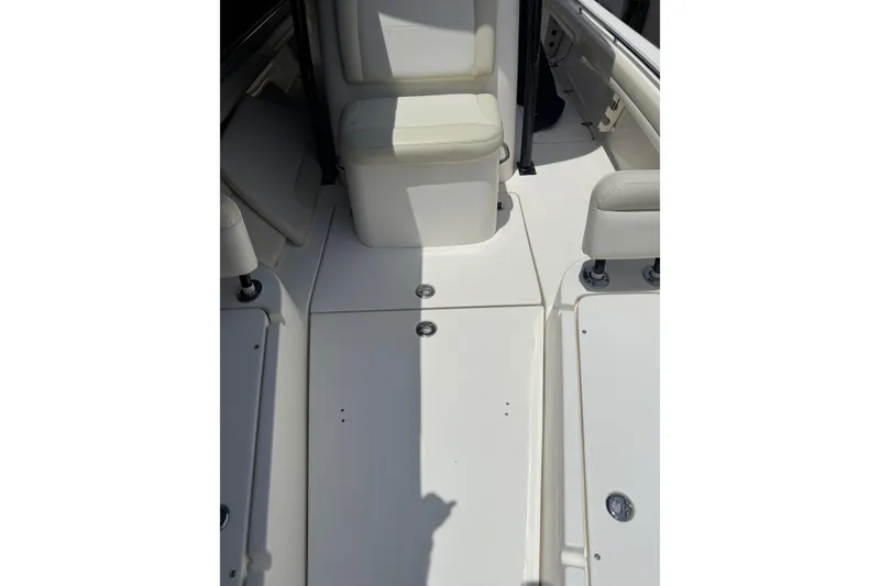 Slide: The Image of Interior view of a 2015 Blackwood 27 boat, featuring white seating and deck. - 23