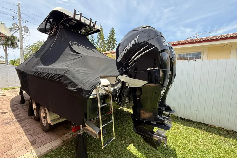 Slide: The Image of Covered Blackwood 27 boat with Mercury Verado engine, parked on a brick driveway. - 3