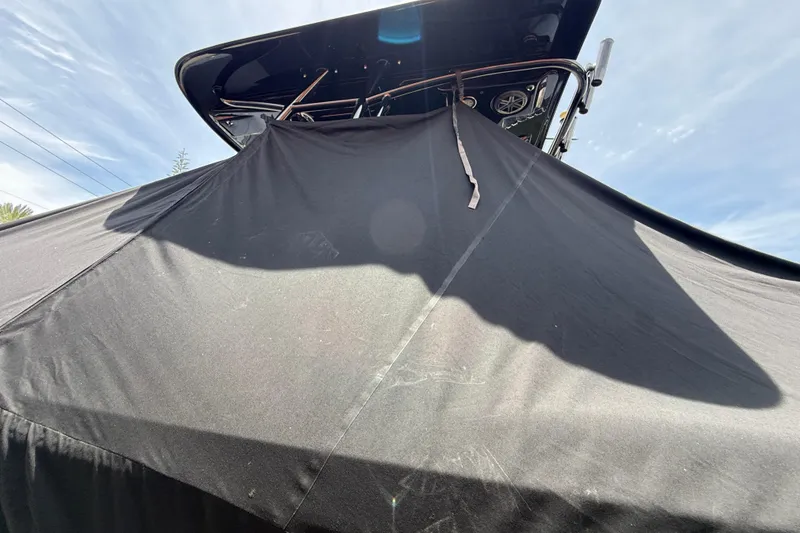 Slide: The Image of Blackwood 27 boat covered with a black tarp, 2015 model, under a clear sky. - 6