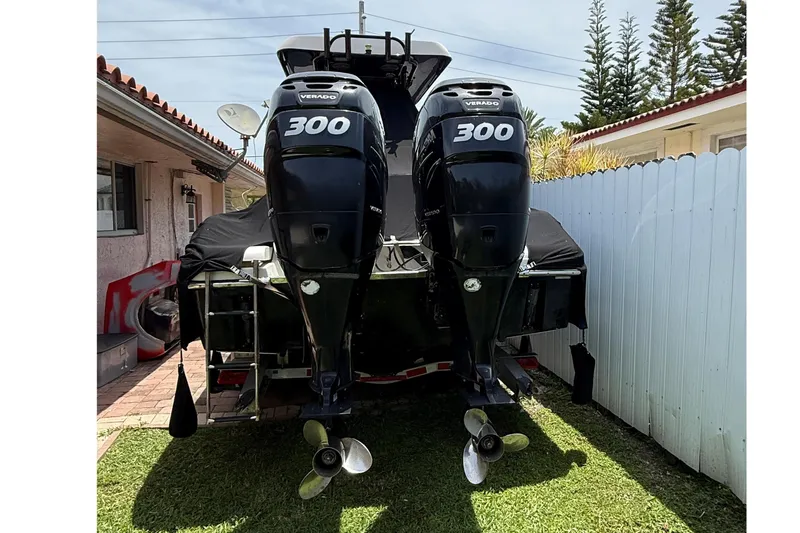 Slide: The Image of 2015 Blackwood 27 boat with twin 300 horsepower engines, parked on grass. - 8