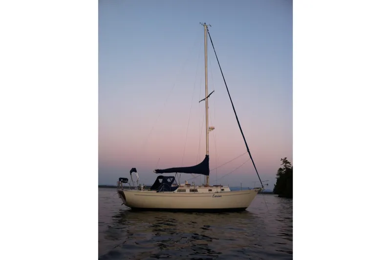 The Image of 1981 Hinterhoeller Niagara 35 sailboat on calm water at sunset. - 0