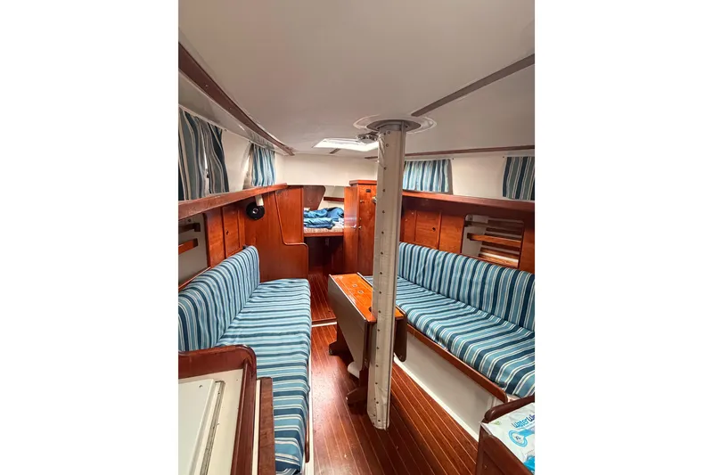 Slide: The Image of Interior of 1981 Hinterhoeller Niagara 35 sailboat with striped seating and wooden finishes. - 1