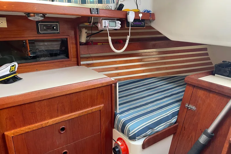 Slide: The Image of Interior of a 1981 Hinterhoeller Niagara 35 sailboat with striped bedding and wooden cabinetry. - 11