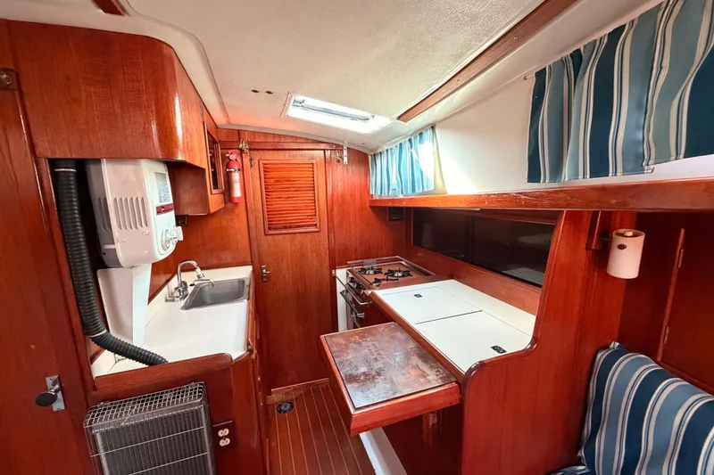 Slide: The Image of 1981 Hinterhoeller Niagara 35 yacht interior with wooden cabinetry and compact kitchen area. - 2