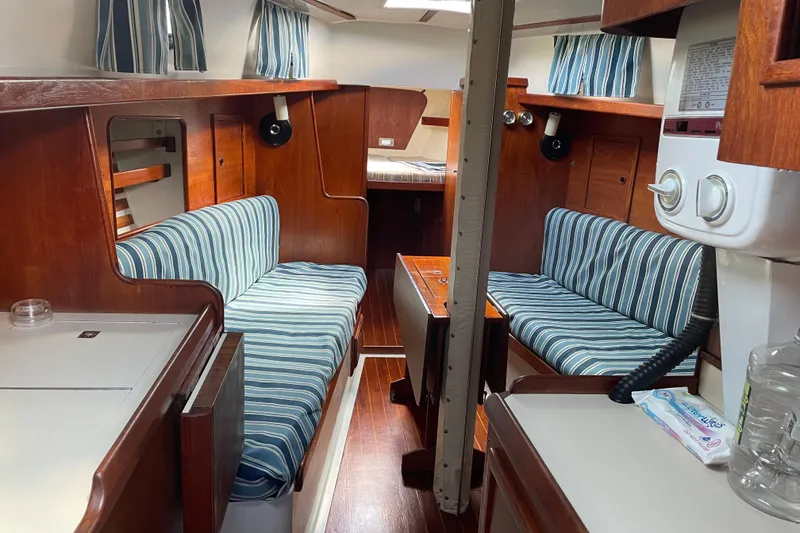 Slide: The Image of Interior of 1981 Hinterhoeller Niagara 35 sailboat with striped upholstery and wooden finishes. - 5