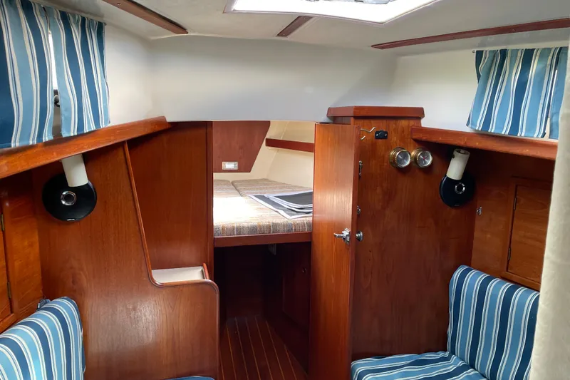 Slide: The Image of Interior of 1981 Hinterhoeller Niagara 35 sailboat with wood finish and striped upholstery. - 6