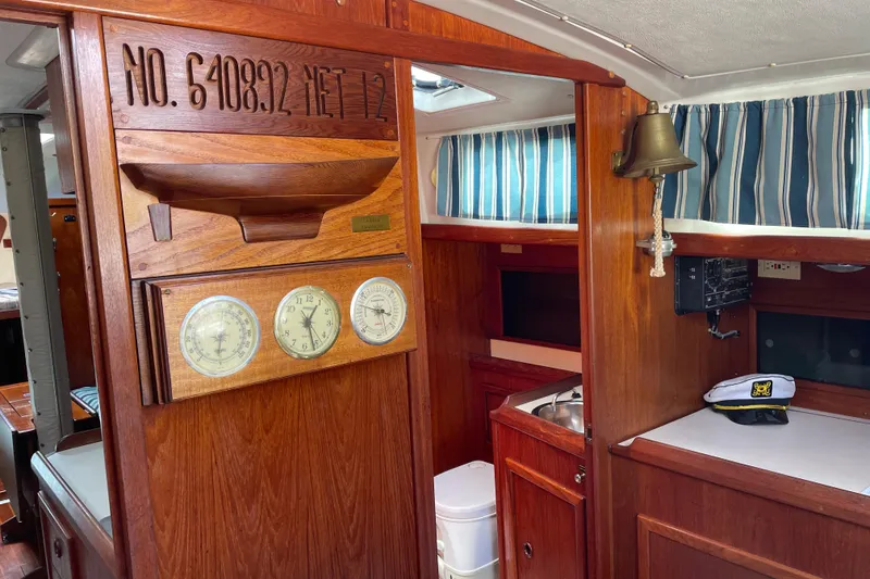 Slide: The Image of Interior of 1981 Hinterhoeller Niagara 35 sailboat with wood paneling and nautical decor. - 9