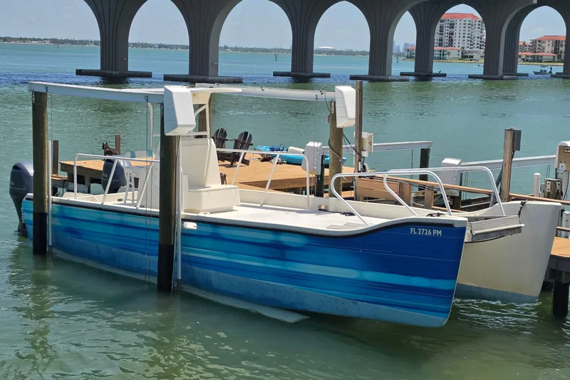 Slide: The Image of Custom 2014 Exuma Catamaran 32 docked near a bridge on a sunny day. - 1