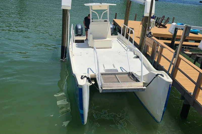 Slide: The Image of 2014 Custom Exuma Catamaran 32 docked on calm water near wooden pier. - 2