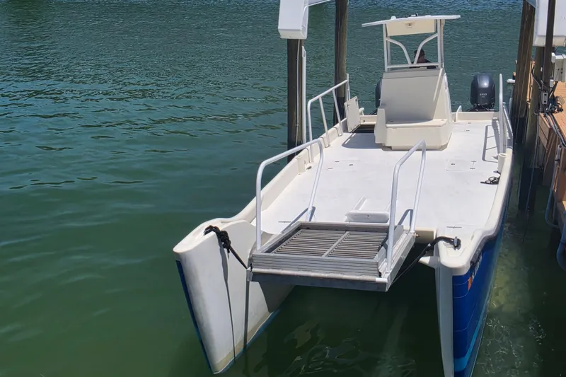 Slide: The Image of 2014 Custom Exuma Catamaran 32 docked on calm water, featuring spacious deck. - 21