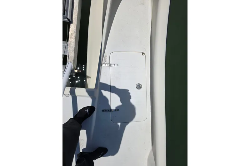 Slide: The Image of Custom Exuma Catamaran 32 (2014) docked near a waterfront home with lush greenery. - 37