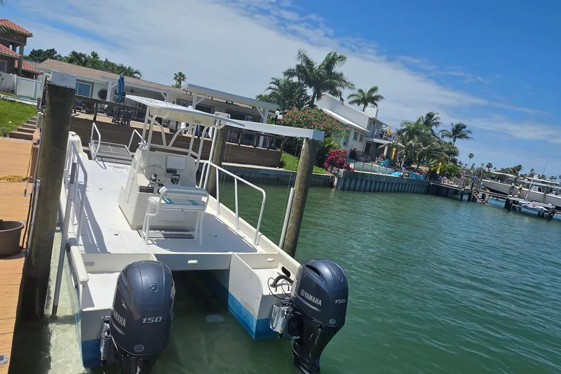 Slide: The Image of 2014 Custom Exuma Catamaran 32 T-top, docked near a bridge on a sunny day. - 45