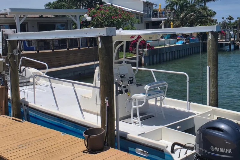 Slide: The Image of 2014 Custom Exuma Catamaran 32 cockpit with dual Yamaha 150 engines and striped seating. - 46