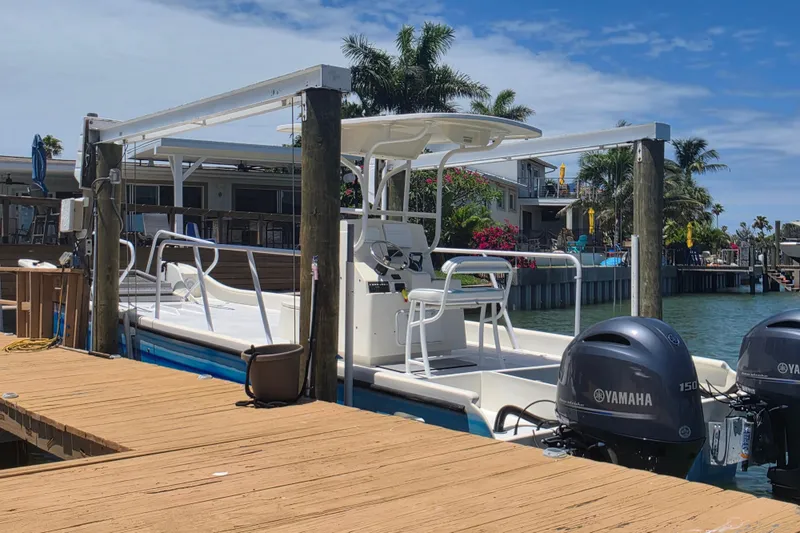 Slide: The Image of Twin Yamaha 150 outboard engines on a 2014 Custom Exuma Catamaran 32 by a dock. - 70