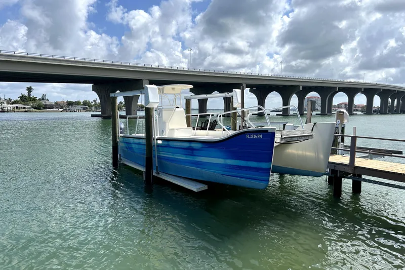 Slide: The Image of Custom Exuma Catamaran 32 (2014) docked near a bridge on a sunny day. - 77