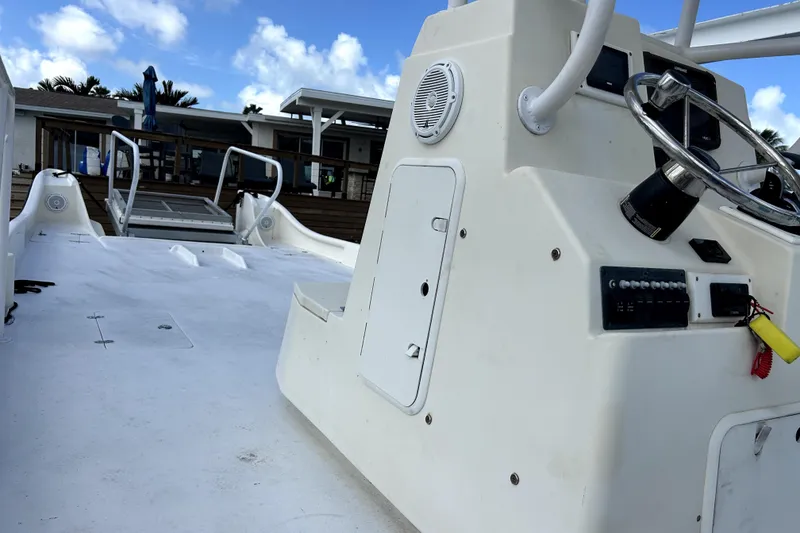 Slide: The Image of 2014 Custom Exuma Catamaran 32 with steering console, docked under blue sky. - 82