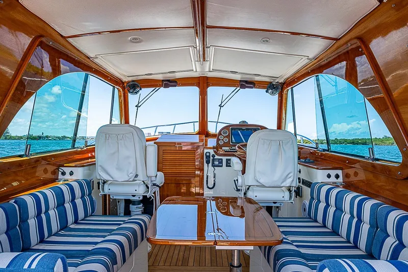 Slide: The Image of Interior of 2015 Hinckley Picnic Boat 37 MKIII with striped seating and wooden finishes. - 13