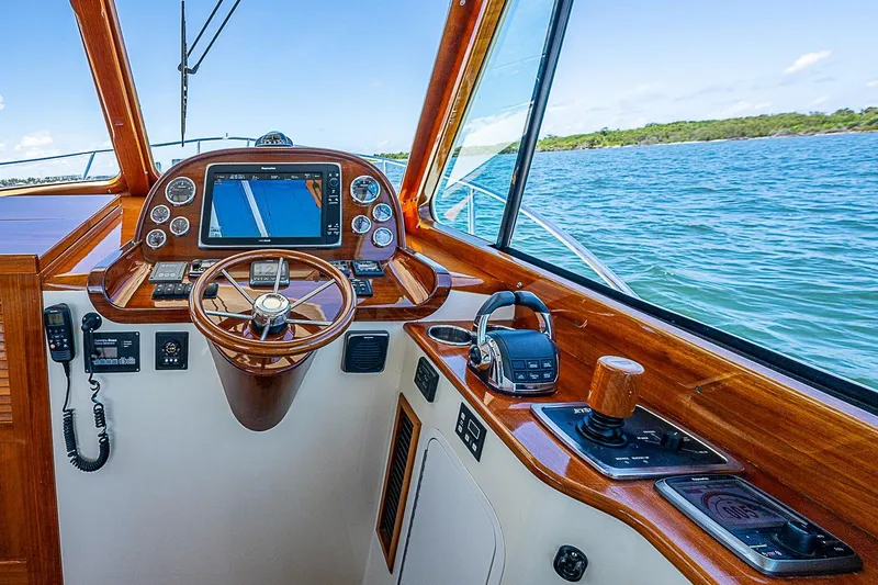 Slide: The Image of Helm of 2015 Hinckley Picnic Boat 37 MKIII with wooden accents and navigation equipment. - 15