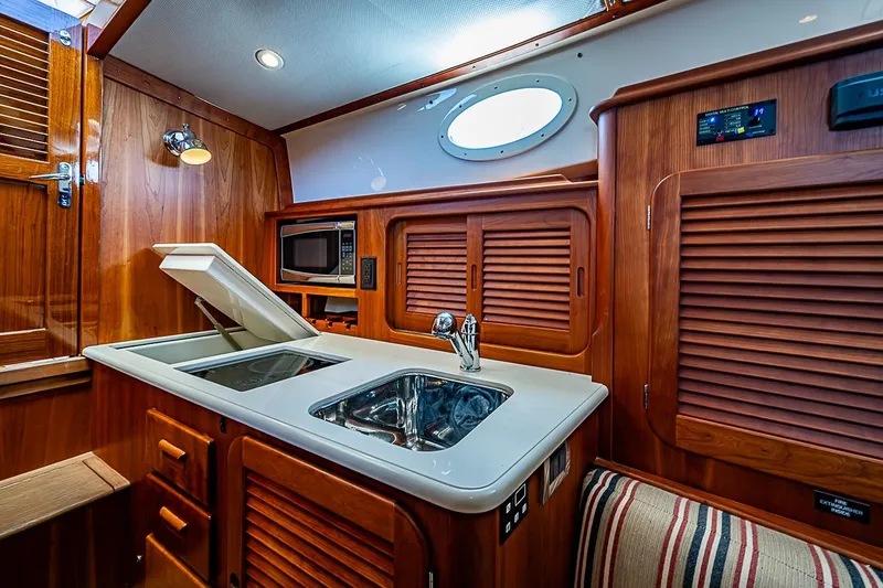 Slide: The Image of Luxurious 2015 Hinckley Picnic Boat 37 MKIII galley with wood cabinetry and modern amenities. - 17