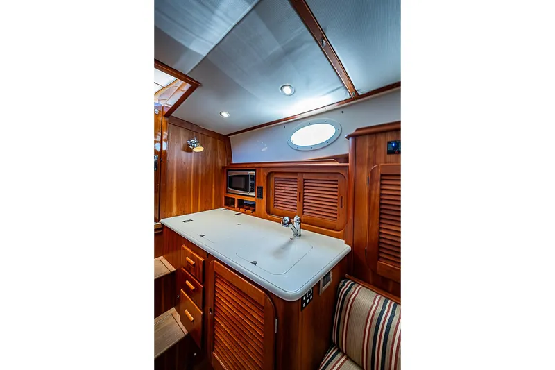 Slide: The Image of Hinckley Picnic Boat 37 MKIII 2015 interior with wooden cabinetry and modern amenities. - 18