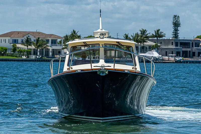 Slide: The Image of 2015 Hinckley Picnic Boat 37 MKIII cruising on a sunny day near waterfront homes. - 2