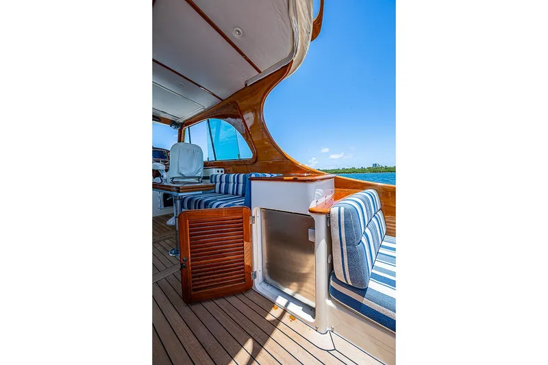 Slide: The Image of 2015 Hinckley Picnic Boat 37 MKIII interior with striped seating and wooden accents. - 8