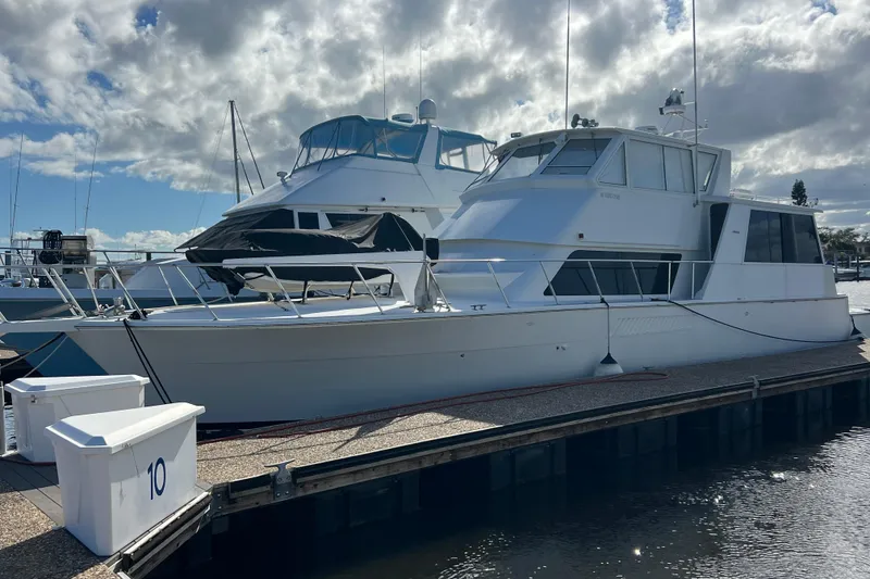 The Image of 1999 Viking 60 CPMY yacht docked at marina under cloudy sky. - 0