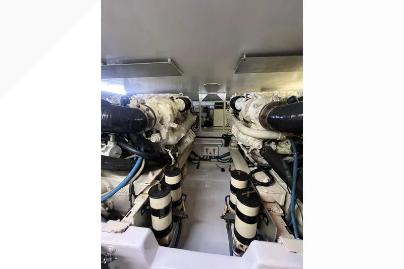 Slide: The Image of Engine room of 1999 Viking 60 CPMY yacht, featuring dual engines and piping. - 120