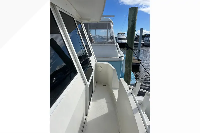 Slide: The Image of 1999 Viking 60 CPMY yacht docked at marina, side view with clear sky. - 18