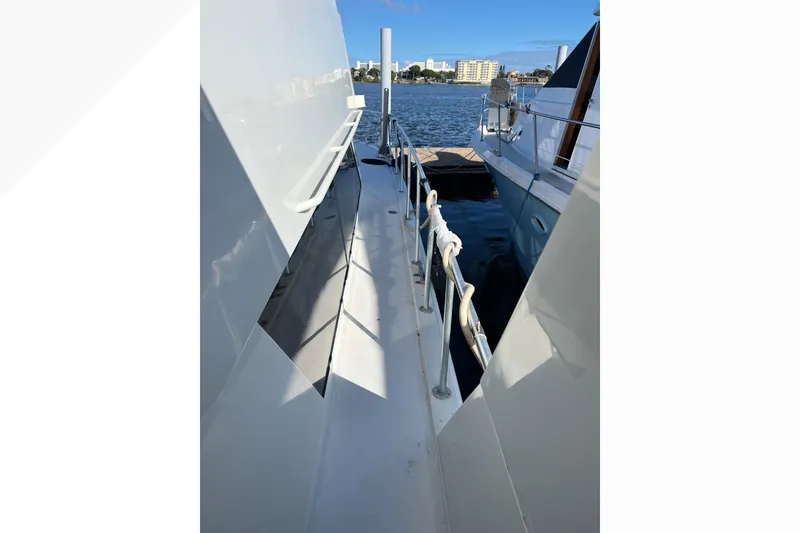 Slide: The Image of Side deck view of 1999 Viking 60 CPMY yacht docked by the water. - 23