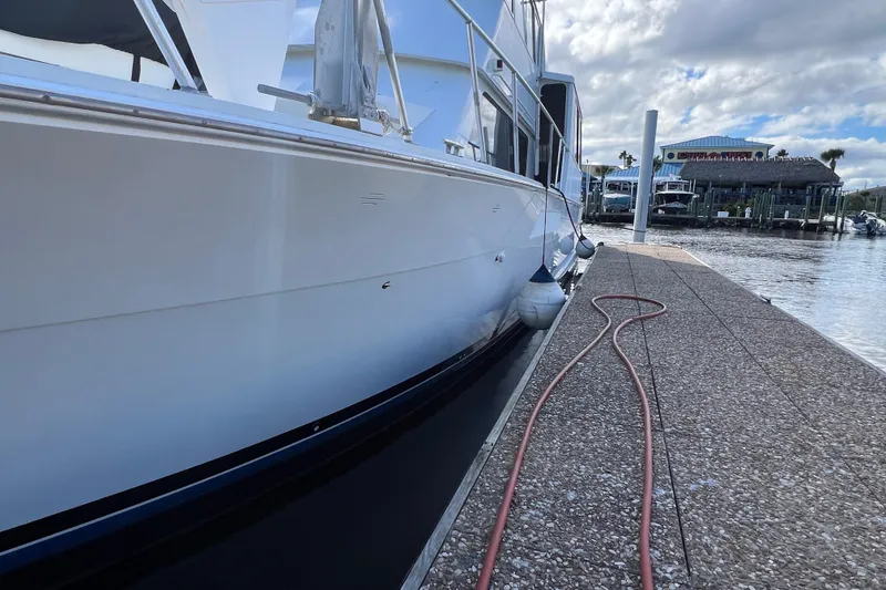 Slide: The Image of 1999 Viking 60 CPMY yacht docked at marina with clear sky and water view. - 4