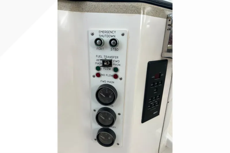 Slide: The Image of Control panel of a 1999 Viking 60 CPMY yacht, featuring emergency shutdown and fuel transfer switches. - 50