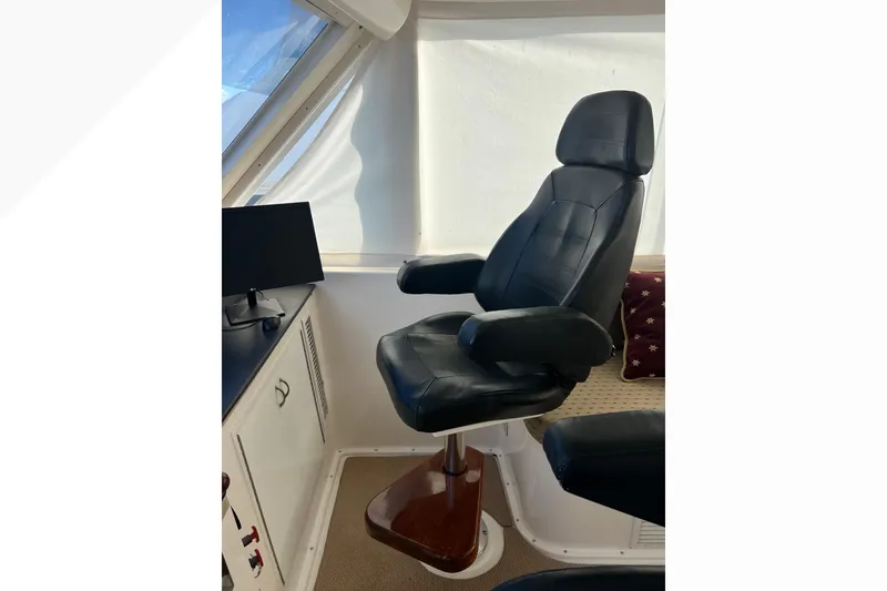 Slide: The Image of Captain's chair in 1999 Viking 60 CPMY yacht helm, with black leather upholstery. - 53