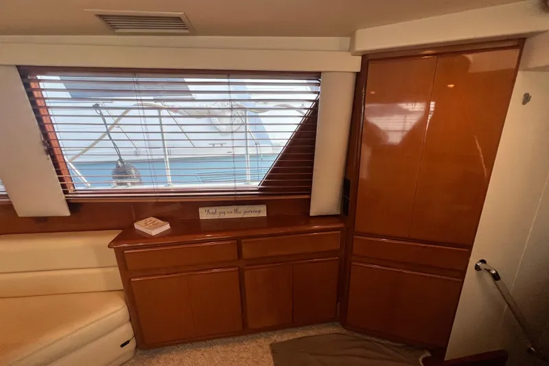 Slide: The Image of Interior of 1999 Viking 60 CPMY yacht with wooden cabinetry and window blinds. - 62
