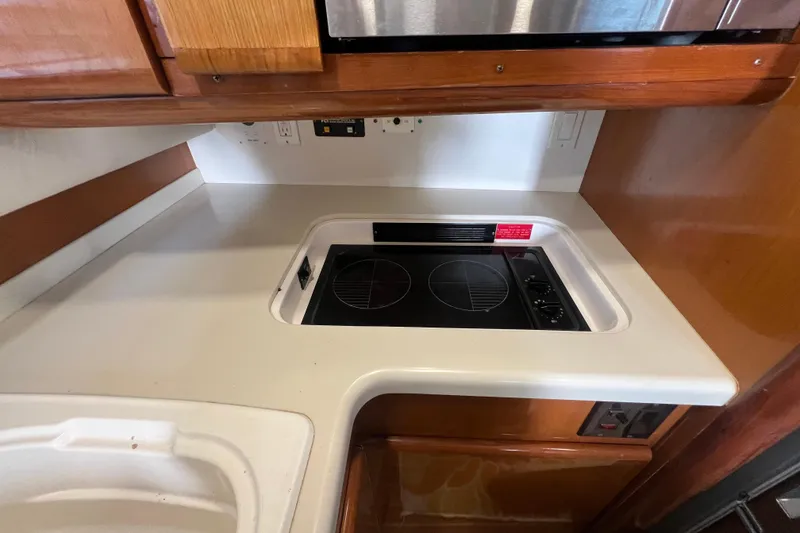 Slide: The Image of 1999 Viking 60 CPMY yacht kitchen with electric stove and wooden cabinetry. - 72