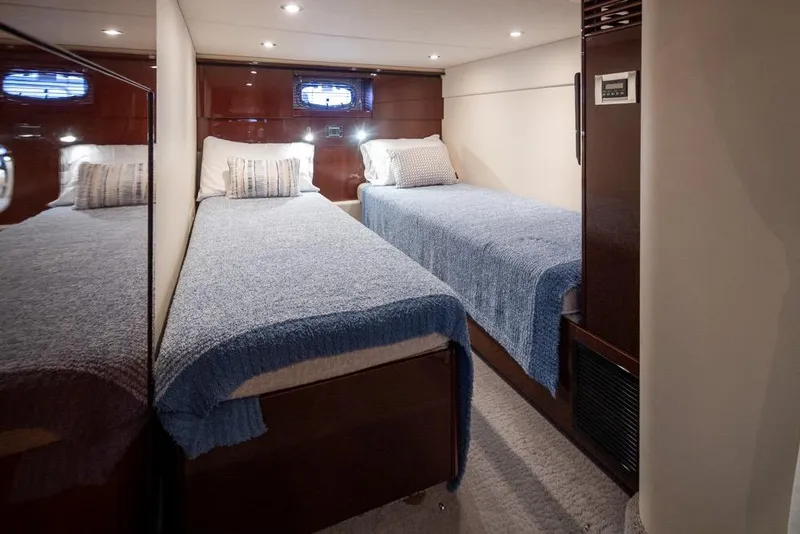 Slide: The Image of Twin beds in a 2010 Sea Ray 500 Sundancer yacht cabin, featuring cozy blue bedding. - 26