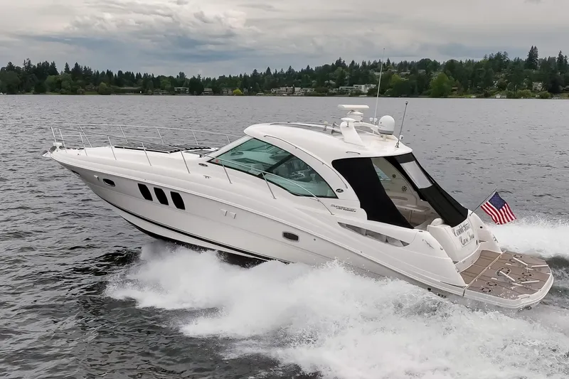 Slide: The Image of 2010 Sea Ray 500 Sundancer cruising on a lake with an American flag. - 31