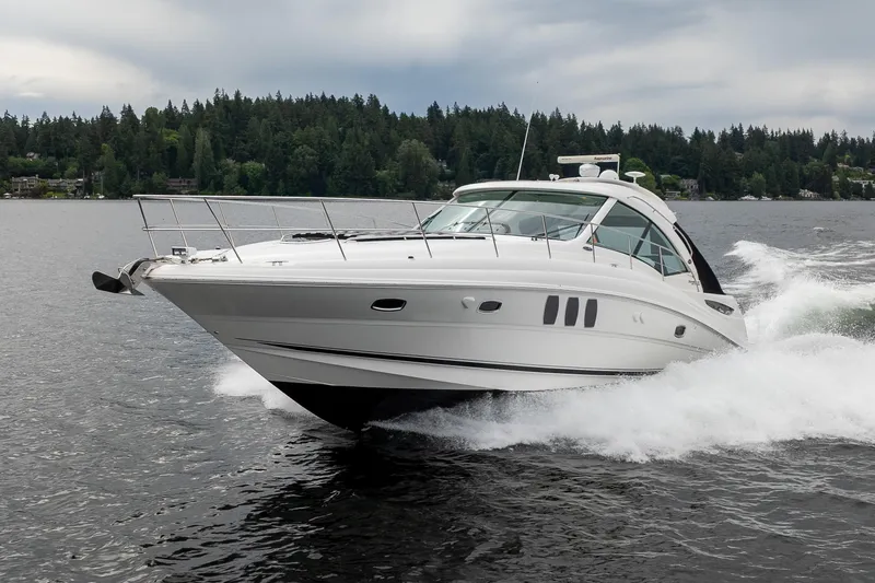Slide: The Image of 2010 Sea Ray 500 Sundancer cruising on a lake with forested shoreline. - 4