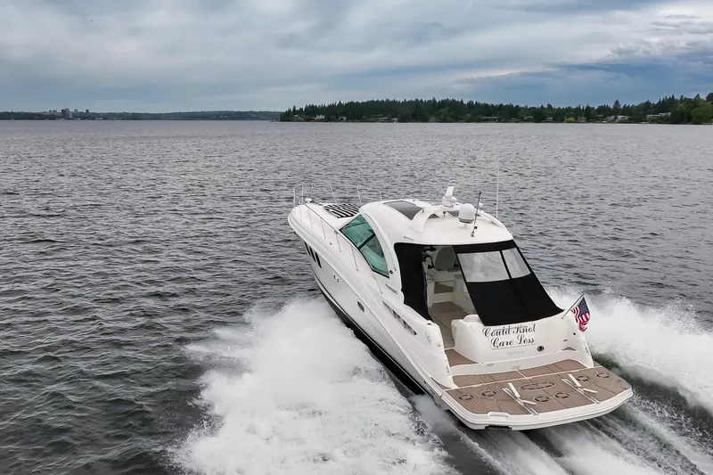Slide: The Image of 2010 Sea Ray 500 Sundancer cruising on a lake under cloudy skies. - 6